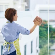 a maid cleaning clear glass